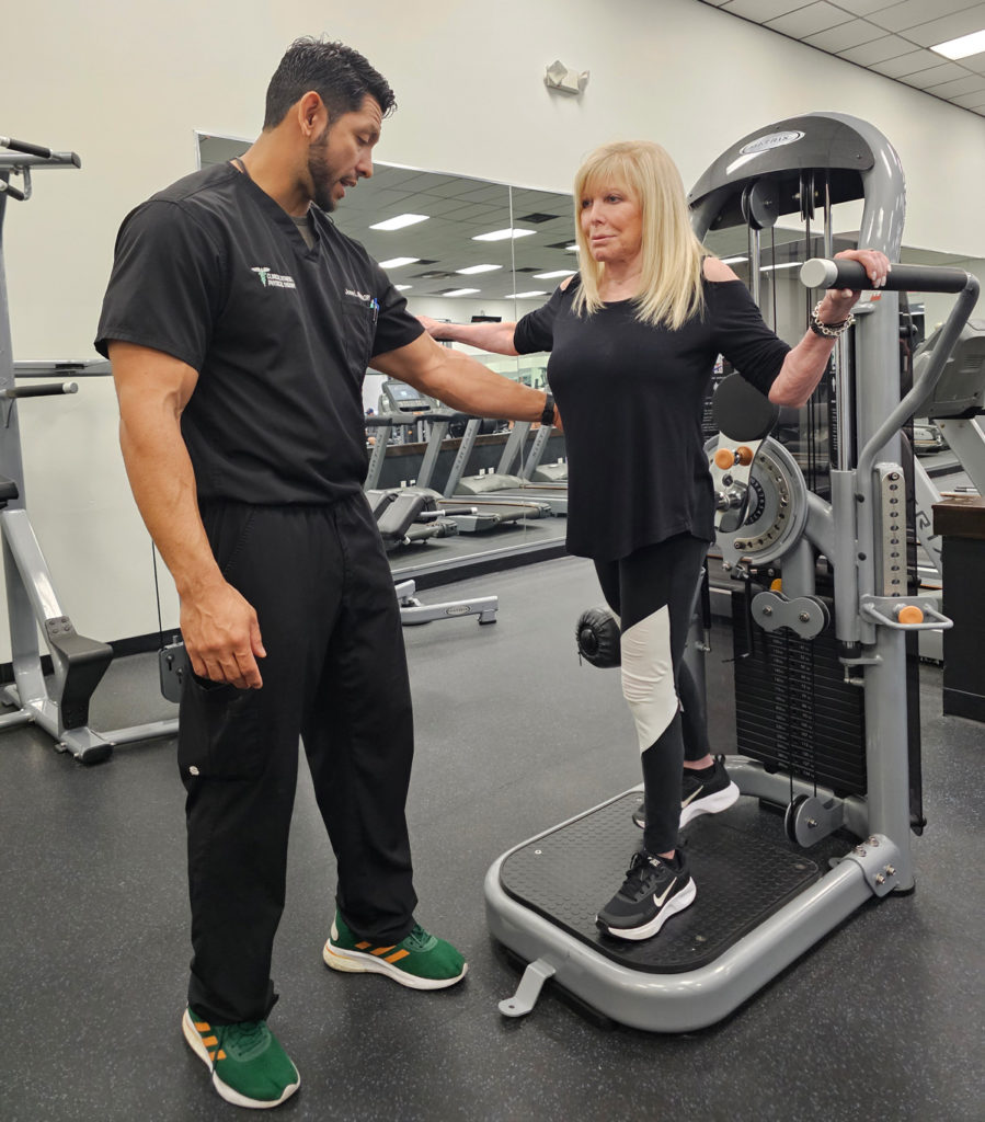 Jose Matta working with older woman at gym