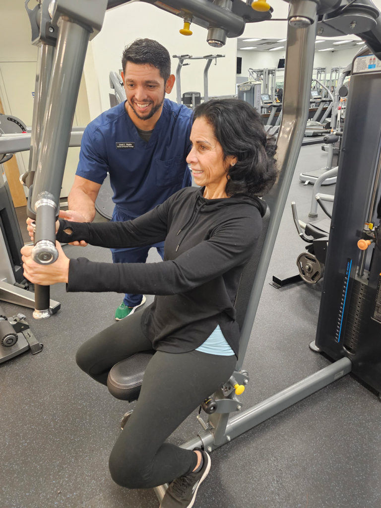 Jose Matta working with older woman at gym